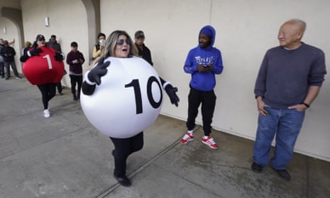 Lottery employees entertain people queueing to buy Powerball tickets in California.