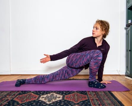 Abi Millar stretching her back on a mat at home