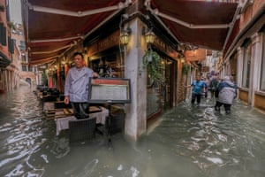 A restaurant owner looks at the flood waters in Venice, Italy