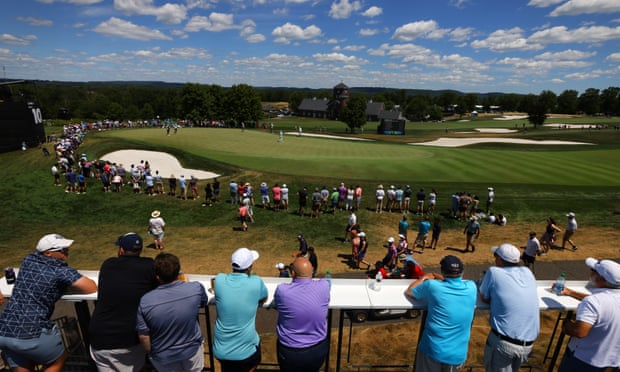 Fans watch play on the 10th green from a distance at Bedminster.