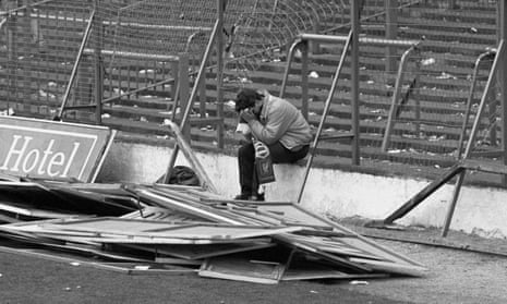 A Liverpool supporter sits in distress at Hillsborough following the carnage there on 15 April 1989