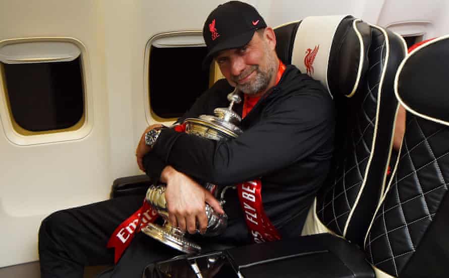 Jürgen Klopp embraces the FA Cup on a flight back to Liverpool after their triumph over Chelsea.