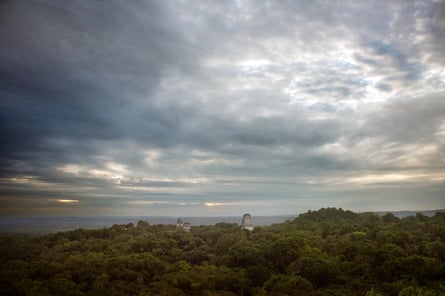 View of forests and sky with towers poking through treetops, relics from the Maya era