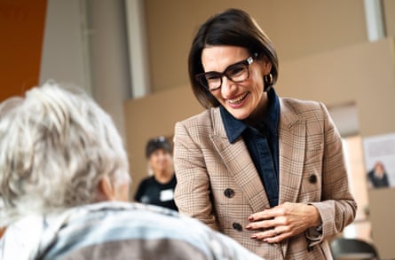 a woman smiling as she greets someone