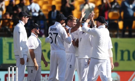 Jimmy Anderson is congratulated by his England teammates after taking his milestone wicket against India.