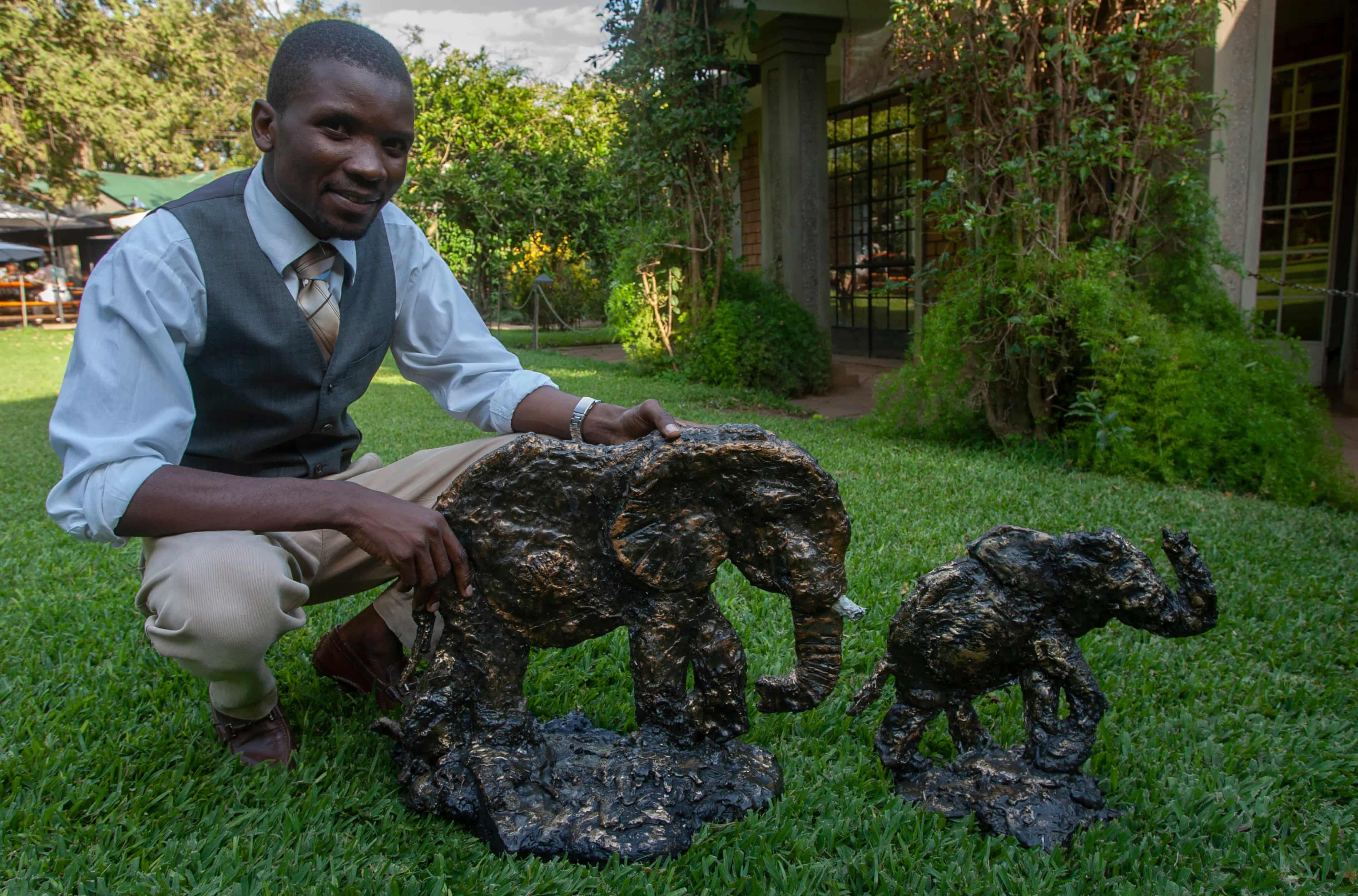 Artist Chisomo Lifa with some of the elephant sculptures he makes from recycled plastic. Photograph: Amos Gumulira/The Guardian