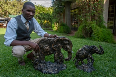 Artist Chisomo Lifa with his sculptural art works of elephants made from recycled plastic.