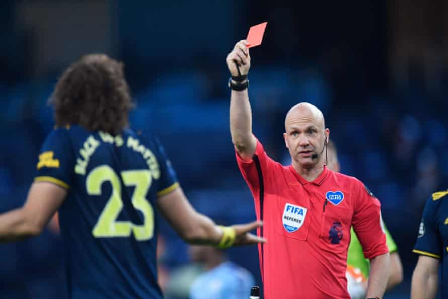 Referee Anthony Taylor shows red.