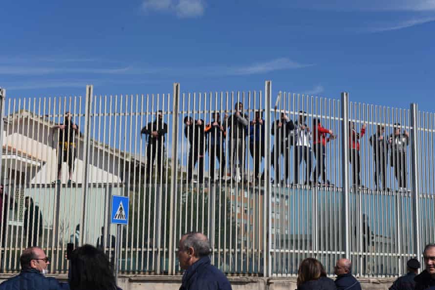 Prisoners climb a fence in Foggia, Italy, 9 March 2020. Violent protests broke out in 27 Italian prisons against coronavirus restrictions on visiting rights.