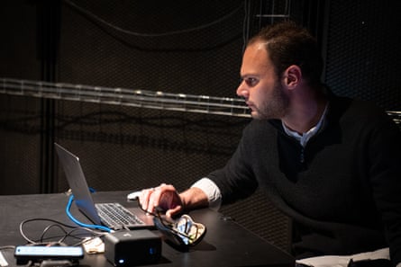 A musical composer sits at a laptop