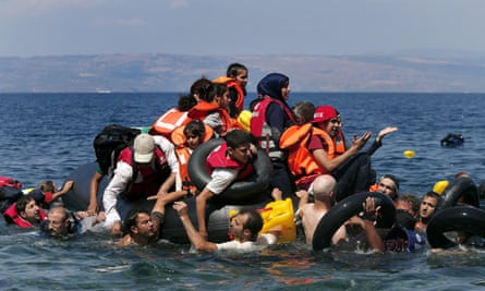 Syrian and Afghan refugees are seen on and around a dinghy that deflated off the shore of Lesbos.