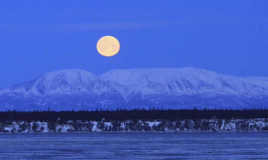 The moon sets over Mount Susitna, across Cook inlet, in Anchorage, Alaska.