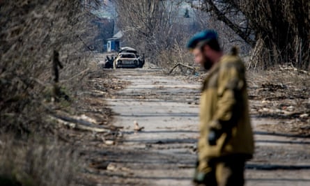 A separatist fighter crosses the road near the spot where a car containing journalists was hit by an anti-tank missile this weekend near Donetsk.