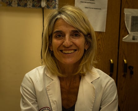 A smiling middle-aged woman in a white lab coat