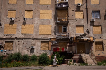 Person walking past a damaged building in downtown Kramatorsk.
