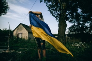 A child planting a flag to set a ‘checkpoint’ in Zelene, Kharkiv region, Ukraine