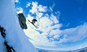 Male off-piste skier jumping off cliff, low angle view (fish eye)