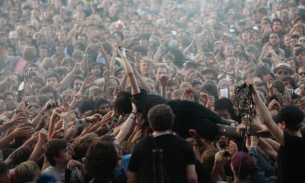 Alice Glass of Crystal Castles stagedives into a moshpit.