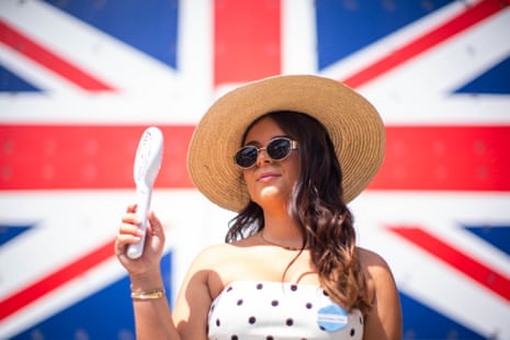 A racegoer using a handheld fan at Royal Ascot in 2025.