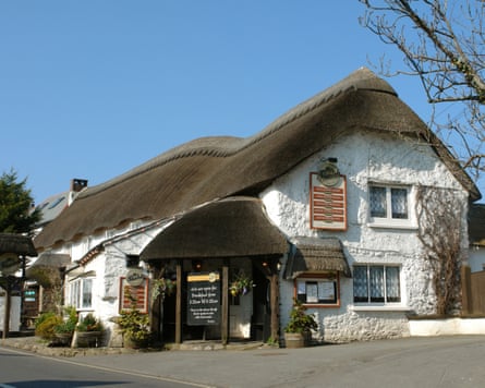 A white rendered pub with a thatched roof