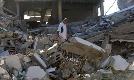 A Palestinian man walks among debris of destroyed buildings in Khan Younis, Gaza.