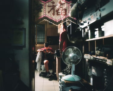 A boy sits and reads while an adult looks towards him