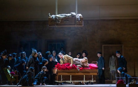 Rolf Romei and Allison Oakes, beneath a suspended Lauren Bridle, with the ENO chorus in The Dead City.
