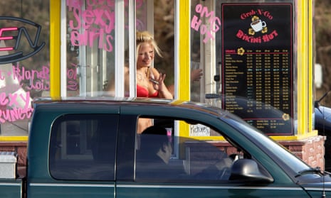 A barista at a Grab-N-Go Bikini Hut espresso stand holds money as she waves to a customer in Everett, Washington. 