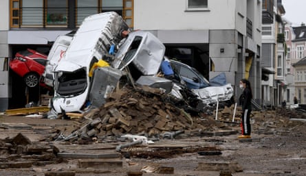 Cars and rubble piled up on a muddy street