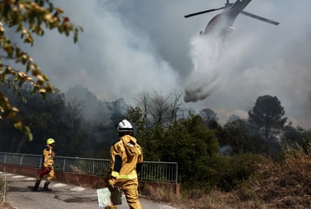 A helicopter drops water over a burning area as a wildfire flares up again in Pontevès, south-eastern France.