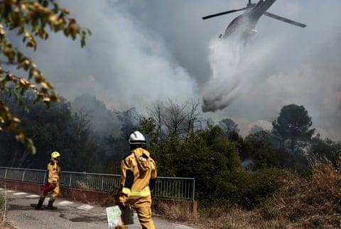 A helicopter drops water over a burning area as a wildfire flares up again in Pontevès, south-eastern France.