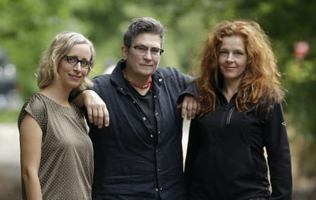 Three woman, with kd lang in the centre leaning her elbows on the others’ shoulders