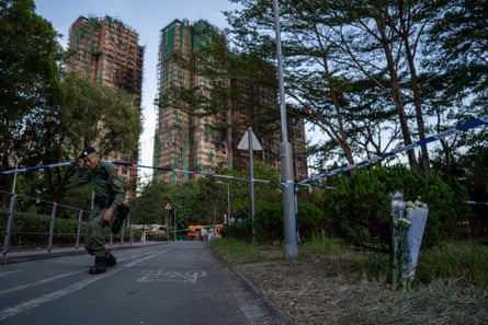 A police officer goes under a barrier near the tower bock