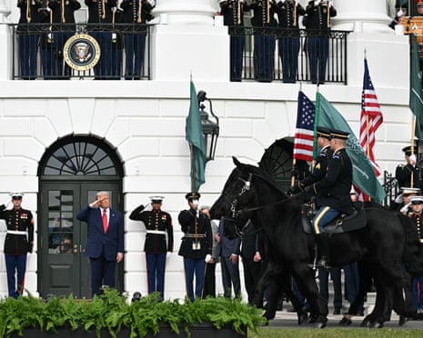 Donald Trump salutes the troops as he waits for the arrival of Mohammed bin Salman.