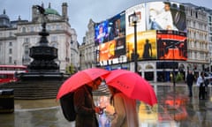 People with umbrellas in the wet weather in Piccadilly Circus, London