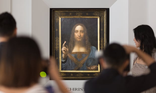 People take photos of Leonardo da Vinci’s Salvator Mundi painting.