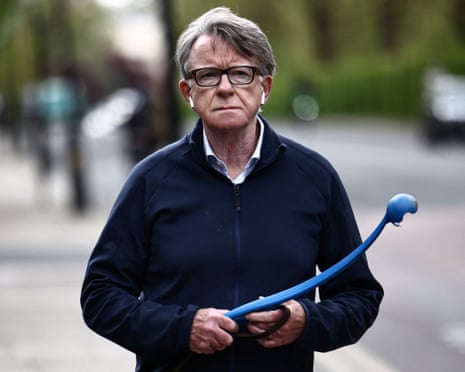 Peter Mandelson out walking his dog, with a ball thrower in his hand