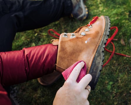 A woman cleaning her hiking boots while outside at home