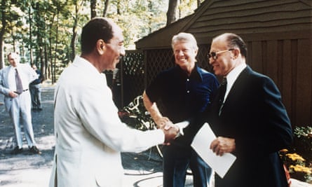 Anwar al-Sadat shakes hands with Menachem Begin as Jimmy Carter looks on, at Camp David in September 1978.