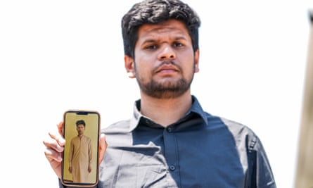 Zohaib Shamraiz holds up a photograph of his missing uncle.