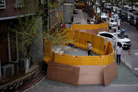 A woman wearing a face mask is seen at a residential area blocked by barriers in Wuhan, Hubei province.