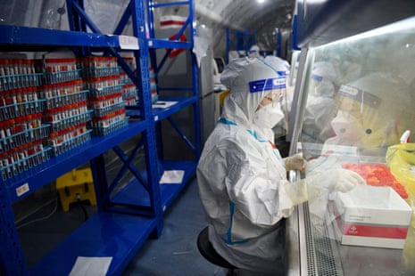 Staff at Sichuan Provincial People's Hospital test Covid samples at a mobile laboratory as authorities battle a coronavirus outbreak in Chengdu, Sichuan province, China.