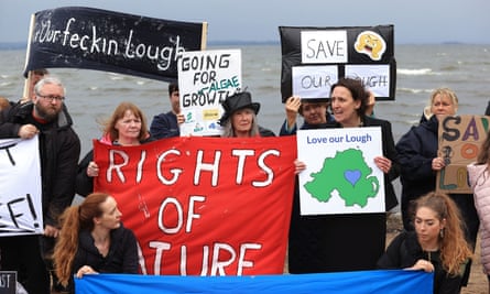 Environmental campaigners next to rough water with protest signs