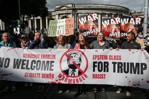 People hold a banner saying ‘No welcome for Trump: genocide enabler, climate denier, Epstein class, racist, warmonger’