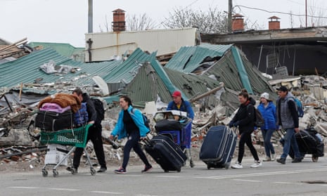Local residents carry belongings as they leave Mariupol.