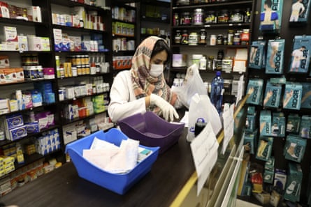 A pharmacist wearing a face mask works in western Tehran.