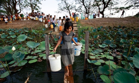 People line up to collect water at Yazarthingyan lake in Dala township, near Yangon, Myanmar.