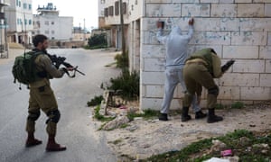 A Palestinian is checked by Israeli soldiers patrolling the streets of the West Bank city of Hebron in 2015.