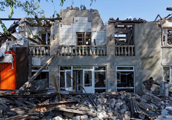 Man looking through rubble of destroyed building