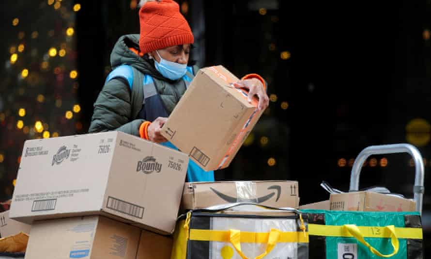 An Amazon delivery worker stacks boxes for delivery on a cart in New York City in November 2021.